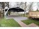 A covered carport and wooden deck enhancing the outdoor living space in the backyard at 4504 Winthrop Ave, Indianapolis, IN 46205