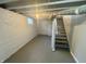 Basement space with painted floor, concrete wall, exposed ceiling, and stairs at 4504 Winthrop Ave, Indianapolis, IN 46205