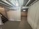 Unfinished basement with exposed ceiling and ductwork, freshly painted walls, and concrete floor at 4504 Winthrop Ave, Indianapolis, IN 46205