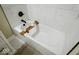 Bright bathtub with white marble tile and modern faucet and shower head at 4504 Winthrop Ave, Indianapolis, IN 46205