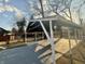 View of the backyard carport with a covered parking area and metal roof and white painted posts at 4504 Winthrop Ave, Indianapolis, IN 46205