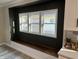 Dining room nook featuring a built-in wooden bench, three windows with white trim, and gray accent wall at 4504 Winthrop Ave, Indianapolis, IN 46205