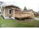 Exterior view of a home featuring a wooden deck, tan siding, and a well-maintained lawn at 4504 Winthrop Ave, Indianapolis, IN 46205