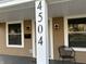 Inviting front porch with house number, chair, and black mailbox and sconces at 4504 Winthrop Ave, Indianapolis, IN 46205