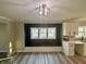 Bright kitchen with white cabinets, modern lighting fixture, large window, and wood-look flooring at 4504 Winthrop Ave, Indianapolis, IN 46205