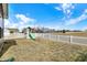 Large backyard showing a playhouse with slide, enclosed by a white picket fence at 491 Tracewood Bnd, Greenfield, IN 46140