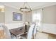 Light-filled dining area with stylish chandelier, wood table, upholstered chairs, and large windows at 491 Tracewood Bnd, Greenfield, IN 46140
