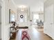 Inviting foyer with wood floors, elegant lighting, console table, and a view into the dining area at 491 Tracewood Bnd, Greenfield, IN 46140