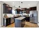 Modern kitchen with dark cabinets, stainless steel appliances, and center island for food prep and entertaining at 491 Tracewood Bnd, Greenfield, IN 46140