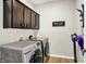 This laundry room features stainless steel washer and dryer, wooden cabinets and hardwood floors at 491 Tracewood Bnd, Greenfield, IN 46140
