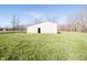 Exterior shot of a metal barn, set on a grassy field with trees in the background, for outdoor storage at 5010 S 550 W, Columbus, IN 47201