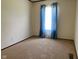 Neutral bedroom with neutral walls, carpet, and window featuring blue curtains at 5010 S 550 W, Columbus, IN 47201