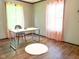 Bright bedroom featuring hardwood floors, neutral walls, and charming pink sheer curtains at 5010 S 550 W, Columbus, IN 47201