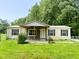 Charming single-story home featuring a covered porch, lawn, and mature trees in a peaceful, private setting at 5010 S 550 W, Columbus, IN 47201