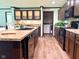 Well-equipped kitchen features an island, dark cabinetry, granite countertops, modern appliances, and wood-style flooring at 5010 S 550 W, Columbus, IN 47201