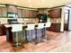 Well-equipped kitchen features an island, dark cabinetry, granite countertops, modern appliances, and wood-style flooring at 5010 S 550 W, Columbus, IN 47201