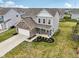 Aerial view of a two-story home with a well-manicured lawn, surrounded by a neighborhood with similar homes at 5520 N Woodside Ct, McCordsville, IN 46055
