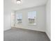 A bright bedroom featuring two windows and neutral carpet, with white walls throughout the room at 5520 N Woodside Ct, McCordsville, IN 46055