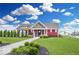 Community clubhouse with green lawn, landscaping, and sidewalk at 5520 N Woodside Ct, McCordsville, IN 46055