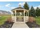 Wooden gazebo on a green lawn with surrounding landscaping and trees at 5520 N Woodside Ct, McCordsville, IN 46055