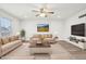 Cozy living room with neutral decor, plush seating, a ceiling fan and ample natural light, creating an inviting atmosphere at 5520 N Woodside Ct, McCordsville, IN 46055