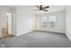 A spacious main bedroom featuring a ceiling fan, windows, neutral carpets, and white walls at 5520 N Woodside Ct, McCordsville, IN 46055