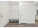 Mud room with white trim, bench, and coat hooks adjacent to interior door and wood look floors at 5520 N Woodside Ct, McCordsville, IN 46055