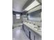 Bathroom featuring a double sink vanity, white tile, and ample lighting at 569 King Dr, Indianapolis, IN 46260
