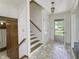 Bright foyer with mosaic tile flooring, staircase, and front door at 569 King Dr, Indianapolis, IN 46260