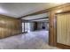 Living room with wood paneling, carpet flooring, and a stone fireplace at 569 King Dr, Indianapolis, IN 46260