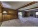 Spacious living room with wood paneled walls, wood beam ceiling, and stone fireplace at 569 King Dr, Indianapolis, IN 46260