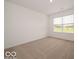 Neutral carpeted bedroom with a large window providing plenty of natural light at 5908 Agogo Way, Greenwood, IN 46143