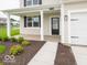 Welcoming front porch with classic columns and a black front door on a charming home at 5908 Agogo Way, Greenwood, IN 46143