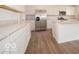 Kitchen with stainless steel refrigerator, white cabinets, and stone countertops, offering a modern look at 5908 Agogo Way, Greenwood, IN 46143
