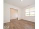 Bright living room with hardwood floors, a window with blinds, and neutral paint at 5908 Agogo Way, Greenwood, IN 46143