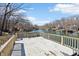 Expansive wooden deck with a bench overlooking the calm waters of the lake and waterfront properties along the shoreline at 6198 Grosbeak Dr, Nineveh, IN 46164
