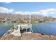 Waterfront view of boat dock on the lake near homesites and wooded surroundings at 6198 Grosbeak Dr, Nineveh, IN 46164