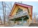 Unique home exterior featuring a gable window, deck, and stone accents, nestled in a wooded setting near the lake at 6198 Grosbeak Dr, Nineveh, IN 46164