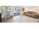 Bright living room with wood floors, tan reclining sofa, and sliding glass doors to the lake at 6198 Grosbeak Dr, Nineveh, IN 46164