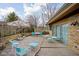 Outdoor back patio area with seating, tables, stone wall accents, and grassy view at 6461 Sunset Ln, Indianapolis, IN 46260