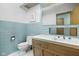Bathroom features a light blue tiled wall, with a unique designed mirror over a wooden vanity at 6461 Sunset Ln, Indianapolis, IN 46260