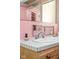 Retro pink bathroom sink and vanity area with decorative accessories at 6461 Sunset Ln, Indianapolis, IN 46260