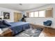 Bedroom showcasing large window, hardwood floors, and a comfortable bed with stylish blue bedding at 6461 Sunset Ln, Indianapolis, IN 46260
