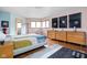 Bedroom with hardwood floors, pastel walls, bay windows and a colorful quilt on the bed at 6461 Sunset Ln, Indianapolis, IN 46260