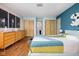 Bedroom with hardwood floors, pastel walls, connecting door to bathroom and quilt on the bed at 6461 Sunset Ln, Indianapolis, IN 46260