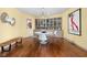 Bright dining room featuring hardwood flooring, retro built-in cabinets, and sleek lighting at 6461 Sunset Ln, Indianapolis, IN 46260