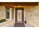 Welcoming entryway with diamond-patterned door, stone walls, and charming decor with accent window at 6461 Sunset Ln, Indianapolis, IN 46260