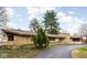 Charming ranch home featuring a stone facade, well-manicured landscaping, and a private driveway at 6461 Sunset Ln, Indianapolis, IN 46260