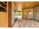 Open and airy hallway with artwork, bench, rug, and screened in porch entrance at 6461 Sunset Ln, Indianapolis, IN 46260