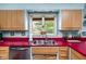 Kitchen sink with view to backyard featuring stainless steel appliances, colorful decor and a large window at 6461 Sunset Ln, Indianapolis, IN 46260